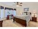 Cozy bedroom with a ceiling fan, a dresser with mirror, and a queen bed with warm neutral linens at 439 Madera Pass, Poinciana, FL 34759