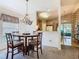 Bright dining area with stylish chandelier adjacent to an open kitchen with light cabinetry at 439 Madera Pass, Poinciana, FL 34759