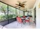 Screened-in patio with ceiling fans, a table and chairs, offering a pleasant outdoor dining experience at 439 Madera Pass, Poinciana, FL 34759