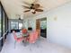 Enclosed patio features ceiling fans, a table with seating, and sliding glass doors to the backyard at 439 Madera Pass, Poinciana, FL 34759