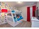 Bright bedroom featuring bunk beds, colorful wallpaper, and red curtains at 4417 Le Reve Ct, Kissimmee, FL 34746