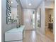 Modern foyer with light tile flooring, mirror, accent table, and a door leading to the bathroom at 4417 Le Reve Ct, Kissimmee, FL 34746