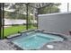Relaxing hot tub area with a waterfall feature, surrounded by lush landscaping and a screened enclosure at 4417 Le Reve Ct, Kissimmee, FL 34746