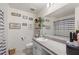 Bright bathroom featuring a vanity with a white sink, decorative wall art, and a gray and white striped shower curtain at 4677 Glencrest Loop, St Cloud, FL 34772