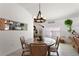 Bright dining area featuring modern chandelier, and seamless flow to the living room with neutral color palette at 4677 Glencrest Loop, St Cloud, FL 34772