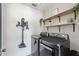 Efficient laundry room featuring modern appliances, wood shelves for storage, and tiled flooring at 4677 Glencrest Loop, St Cloud, FL 34772