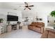 Spacious living room with white floors, an entertainment center, and a seamless connection to the open kitchen at 4677 Glencrest Loop, St Cloud, FL 34772
