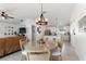 Open-concept living space with a chandelier, white floors, and natural light, seamlessly connecting to the kitchen at 4677 Glencrest Loop, St Cloud, FL 34772