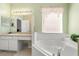 Bathroom with a white vanity, mirror, and garden tub at 4692 Sw Golden Beach N Ct, Kissimmee, FL 34746