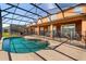 Backyard pool under a screened enclosure with outdoor seating and a scenic view at 4692 Sw Golden Beach N Ct, Kissimmee, FL 34746