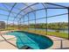 A pristine backyard pool with screened enclosure offering a serene view of the lake at 4692 Sw Golden Beach N Ct, Kissimmee, FL 34746