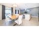 Dining room with modern table, chandelier, sliding door, and view into the living space at 4835 Lullaby Ln, Kissimmee, FL 34746