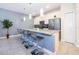Kitchen island with gray stools, stainless appliances, pendant lights and white cabinets at 4835 Lullaby Ln, Kissimmee, FL 34746