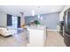 Open concept kitchen with white cabinets, center island, stainless appliances, and tile floors at 4835 Lullaby Ln, Kissimmee, FL 34746