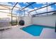 Screened in pool area with a grill and lounge seating under a blue sky at 4835 Lullaby Ln, Kissimmee, FL 34746