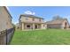 Large backyard featuring lush lawn, a covered patio, and a black fence at 545 Fairhaven Dr, Davenport, FL 33837