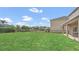 Large backyard offering a covered patio and unobstructed views of the pond, enclosed by a sleek, black fence at 545 Fairhaven Dr, Davenport, FL 33837