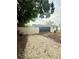 Large gravel backyard provides a versatile space, enclosed by a white fence and mature trees at 6337 Lido Ct, Orlando, FL 32807