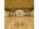 Spacious indoor basketball court with vibrant artwork at center court and high ceilings with industrial lighting at 64 Citrine Loop, Kissimmee, FL 34758