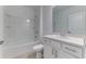 Bright bathroom features a shower-tub combo, single sink with white cabinets and a large mirror at 64 Citrine Loop, Kissimmee, FL 34758