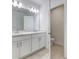 Bright bathroom featuring a double vanity, quartz countertop, and tiled floors at 64 Citrine Loop, Kissimmee, FL 34758