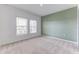 Comfortable bedroom featuring carpet flooring, a large window, and soft, neutral walls at 64 Citrine Loop, Kissimmee, FL 34758