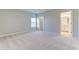 Bright, carpeted bedroom showcasing a window and doors to a walk-in closet and ensuite bathroom at 64 Citrine Loop, Kissimmee, FL 34758