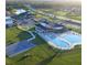 Aerial view of a community pool, basketball court, and clubhouse with parking lot on a sunny day at 64 Citrine Loop, Kissimmee, FL 34758