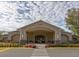 Exterior shot of a building with covered entrance and meticulous landscaping and parking lot in front at 64 Citrine Loop, Kissimmee, FL 34758