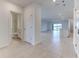 Bright foyer featuring neutral tile flooring and entry to the open-concept living area with bathroom access at 64 Citrine Loop, Kissimmee, FL 34758