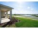 Relax on the front porch of this home, featuring a lush lawn and serene water view at 64 Citrine Loop, Kissimmee, FL 34758