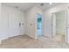 Hallway featuring neutral tile flooring with bedroom and bathroom doors, leading to the home's entrance at 64 Citrine Loop, Kissimmee, FL 34758