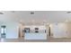 Open-concept kitchen with white cabinets, stainless steel appliances, and an island, viewed from the living area at 64 Citrine Loop, Kissimmee, FL 34758