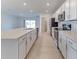 Open-concept kitchen with a large island, stainless steel appliances, and white cabinetry at 64 Citrine Loop, Kissimmee, FL 34758