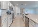 Bright kitchen featuring white cabinets, stainless steel appliances, and a spacious island with a sink at 64 Citrine Loop, Kissimmee, FL 34758