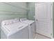 Functional laundry room with modern appliances and ample shelving at 64 Citrine Loop, Kissimmee, FL 34758