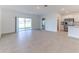 Bright living room with a sliding glass door to the backyard, neutral walls, and tile floors at 64 Citrine Loop, Kissimmee, FL 34758