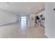 Open-concept living area with neutral tile flooring, flowing into a kitchen with stainless steel appliances at 64 Citrine Loop, Kissimmee, FL 34758