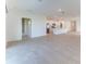 Open-concept living area with tile floors and a kitchen with stainless steel appliances in the background at 64 Citrine Loop, Kissimmee, FL 34758