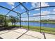 Screened-in patio featuring beautiful water view, tile flooring, and metal enclosure at 782 Vineyard Way, Poinciana, FL 34759