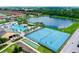 Aerial view of community amenities including a pool, tennis courts, and a lake at 8945 Cuban Palm Rd, Kissimmee, FL 34747
