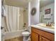 Bathroom featuring a tub with shower, toilet, vanity and decorative wall art and clock at 8945 Cuban Palm Rd, Kissimmee, FL 34747