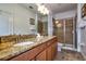 Bathroom featuring double sinks with granite countertops and a glass-enclosed shower at 8945 Cuban Palm Rd, Kissimmee, FL 34747
