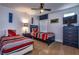 Cozy bedroom with twin beds, ceiling fan, carpet, and a blue dresser and accents at 8945 Cuban Palm Rd, Kissimmee, FL 34747