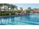 Community pool area with tropical landscaping, rock waterfall feature, and lounge seating at 8945 Cuban Palm Rd, Kissimmee, FL 34747