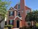 Inviting two-story condo showcasing a peach facade, surrounded by lush trees and meticulous landscaping at 9061 Lee Vista Blvd # 1303, Orlando, FL 32829