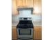 Close up of the electric oven with a stainless steel backsplash, framed by light wood cabinets at 9061 Lee Vista Blvd # 1303, Orlando, FL 32829