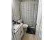 Cozy bathroom featuring a single sink vanity with a granite countertop and a shower with a striped curtain at 10197 Ridgebloom Ave, Orlando, FL 32829