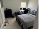 Modern bedroom with a platform bed, dark dresser, and a workstation with multiple monitors at 10197 Ridgebloom Ave, Orlando, FL 32829