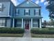 Charming two-story blue home with a red front door and white column-lined porch at 10197 Ridgebloom Ave, Orlando, FL 32829